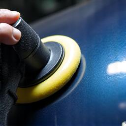 Professional inspecting car paint for imperfections
